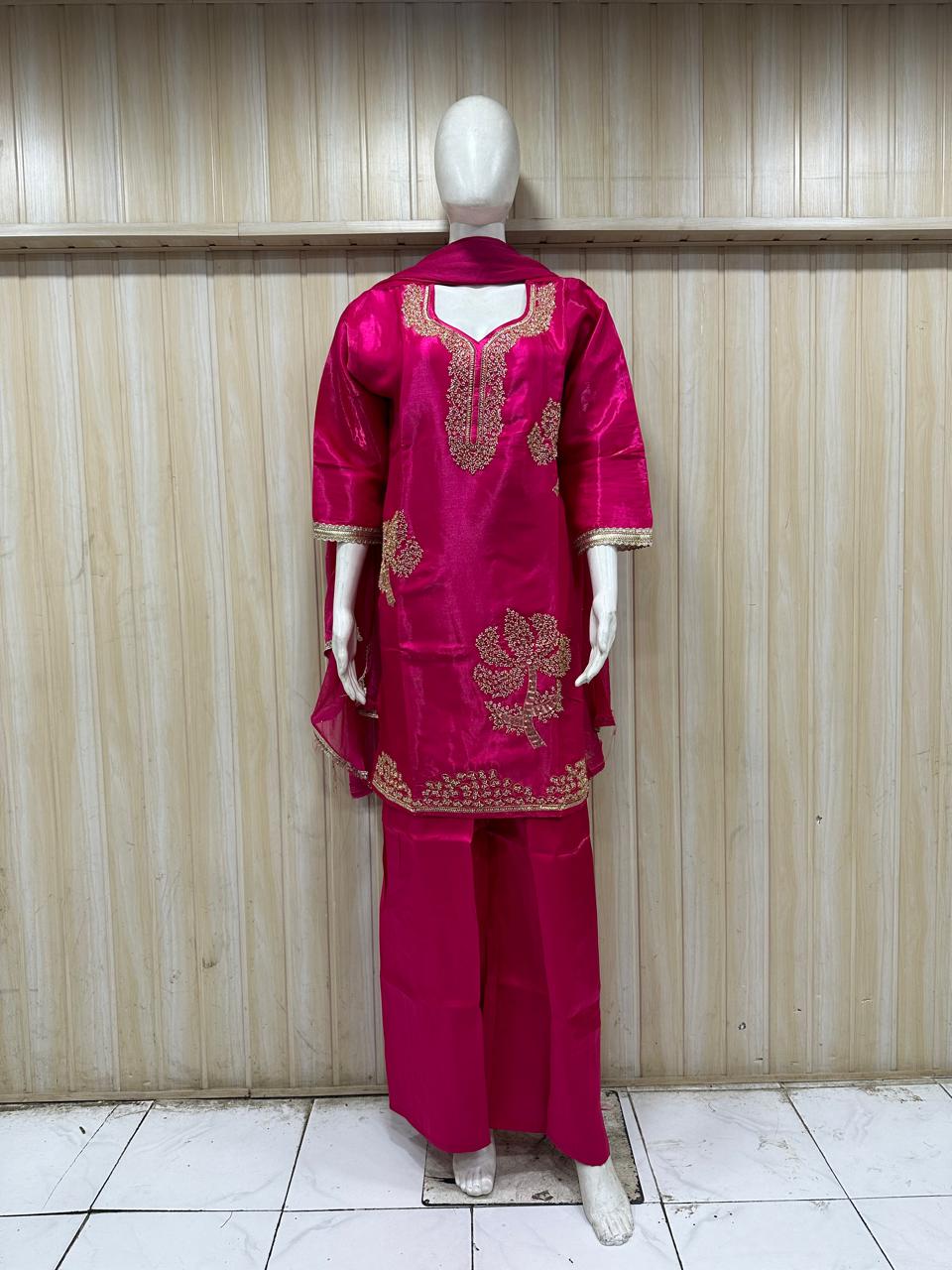 dark pink traditional outfit with matching dupatta on a mannequin against a striped