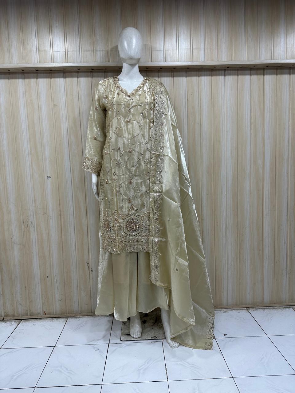 beige traditional outfit with matching dupatta on a mannequin against a striped