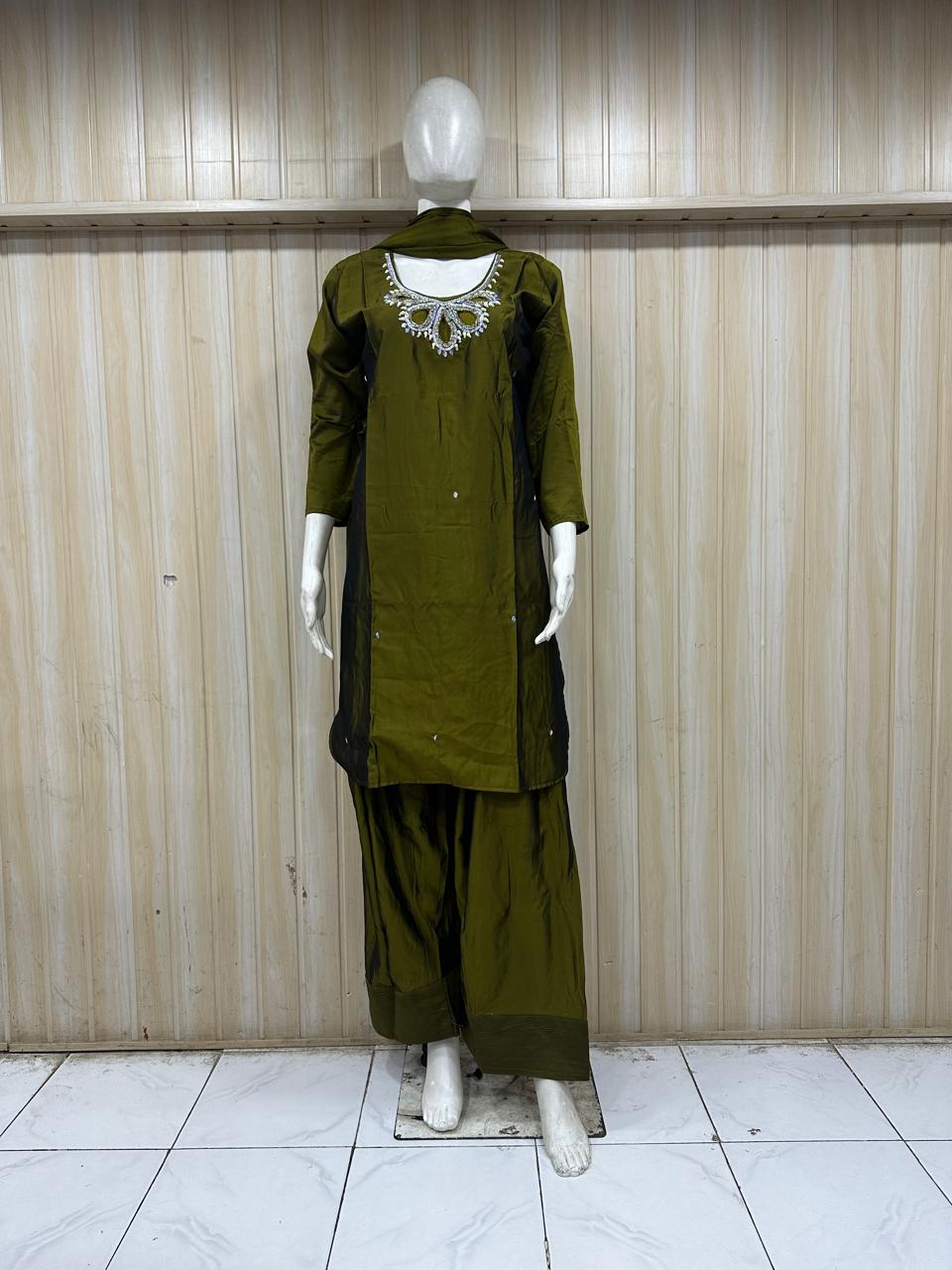 green traditional outfit with matching dupatta on a mannequin against a striped