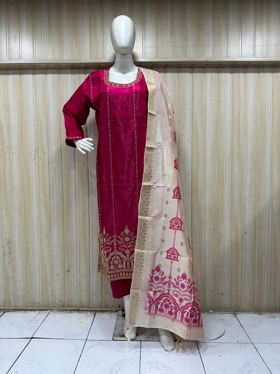 dark pink traditional outfit with matching dupatta on a mannequin against a striped