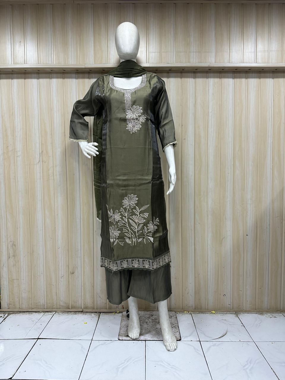 dark green traditional outfit with matching dupatta on a mannequin against a striped