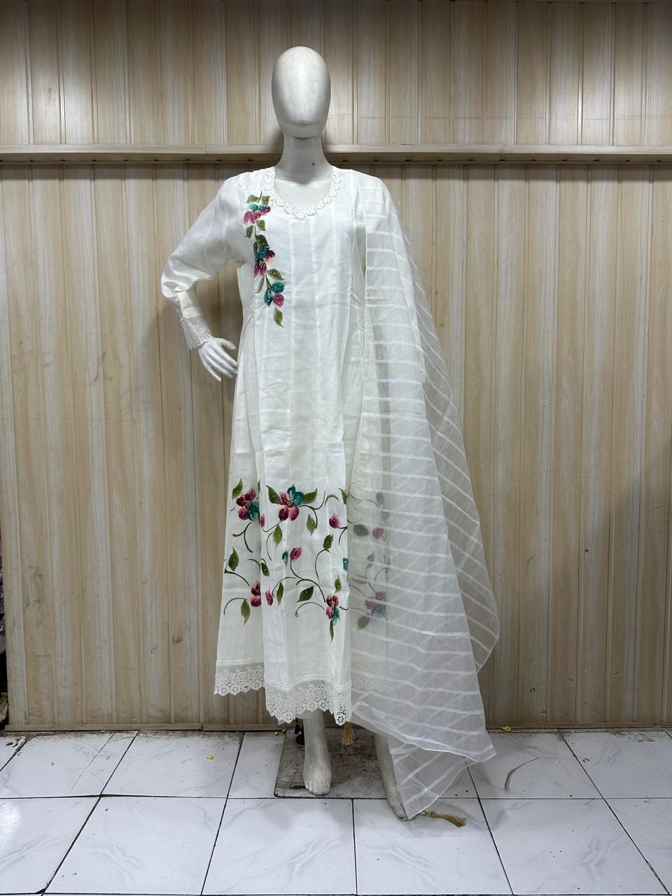 white amrela traditional outfit with matching dupatta on a mannequin against a striped