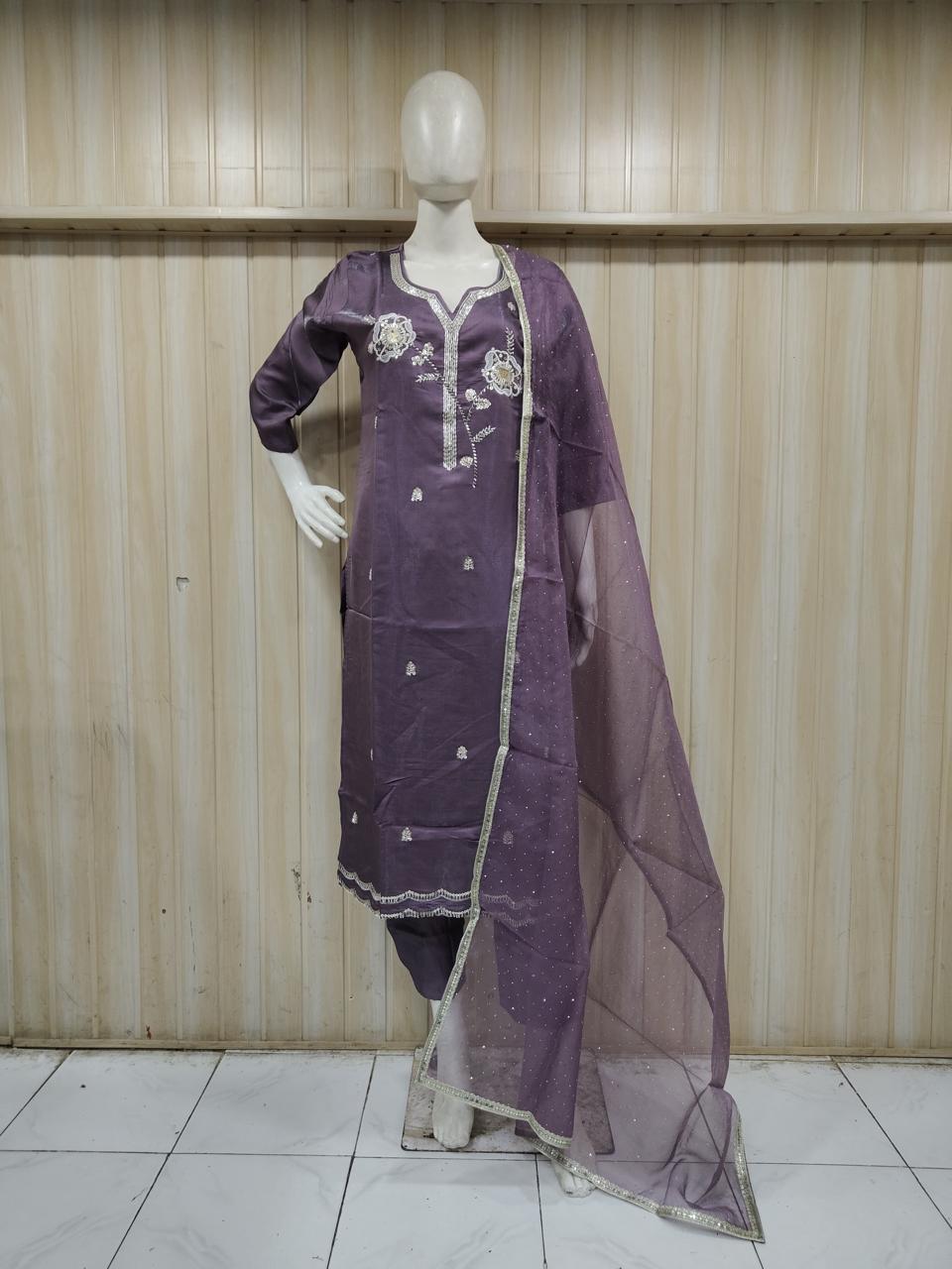 purple traditional outfit with matching dupatta on a mannequin against a striped
