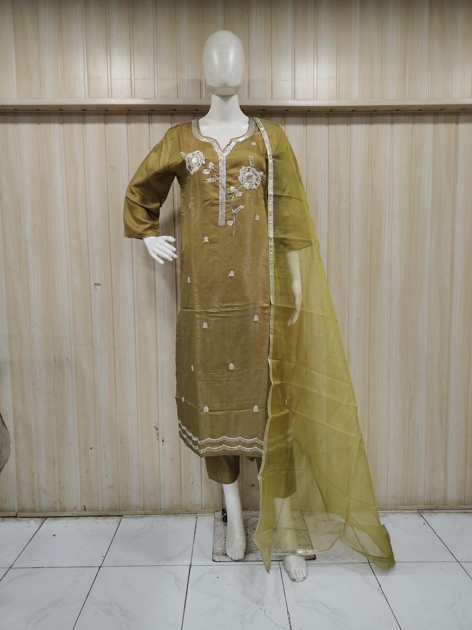 yellow traditional outfit with matching dupatta on a mannequin against a striped
