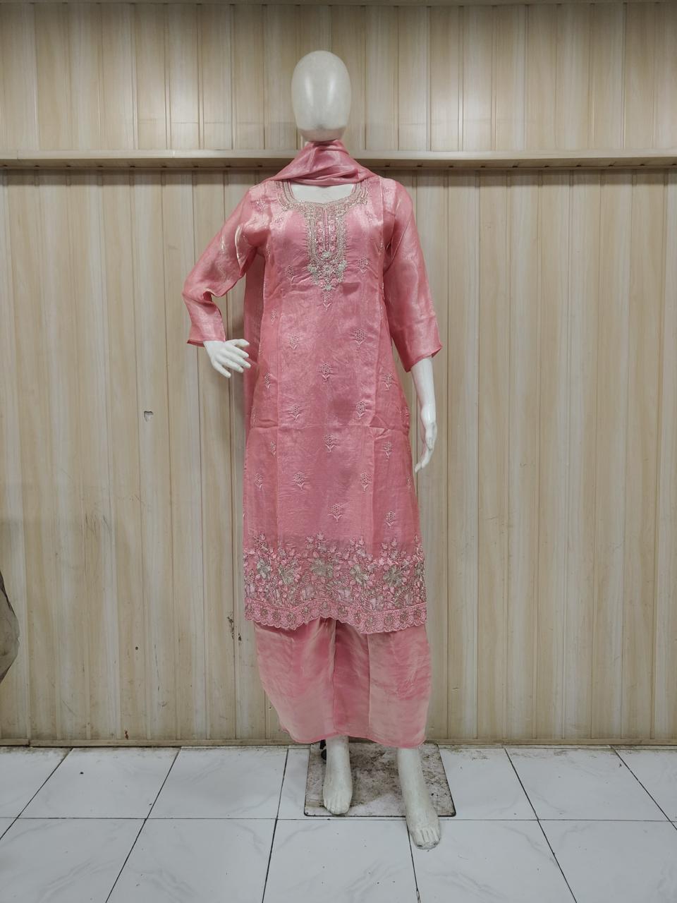pink gold traditional outfit with matching dupatta on a mannequin against a striped