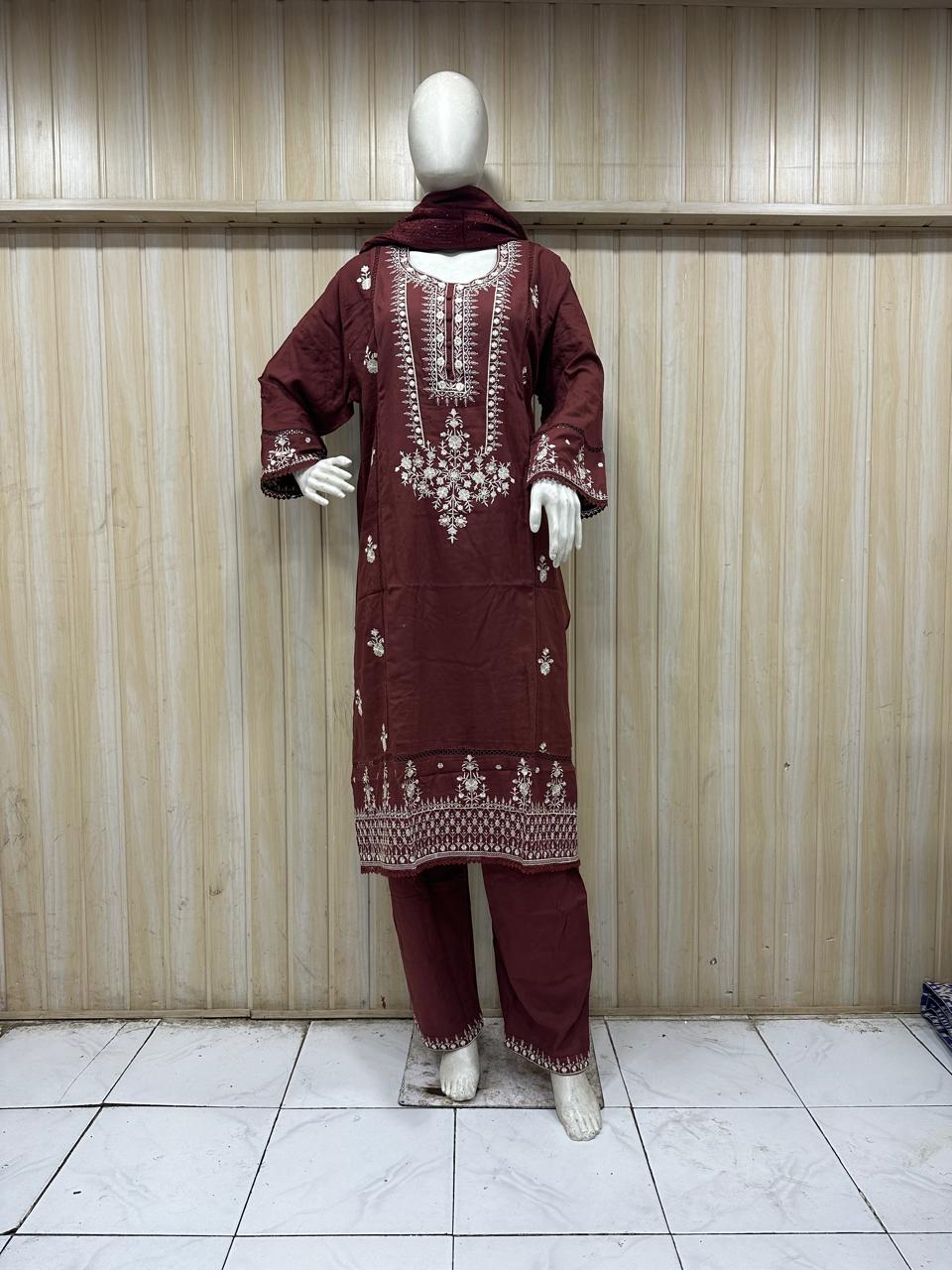 red gold traditional outfit with matching dupatta on a mannequin against a striped