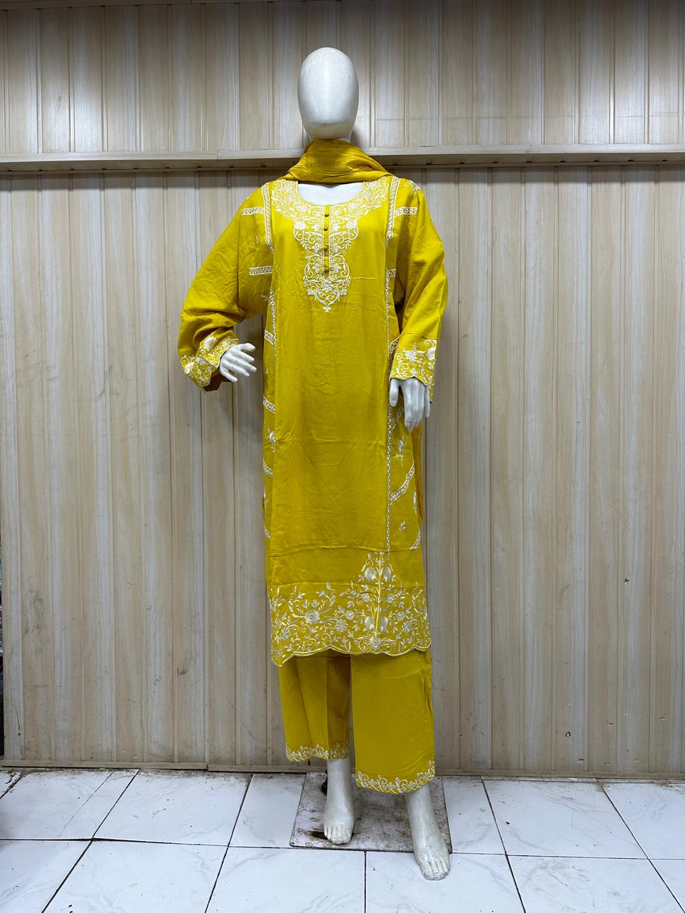 yellow gold traditional outfit with matching dupatta on a mannequin against a striped