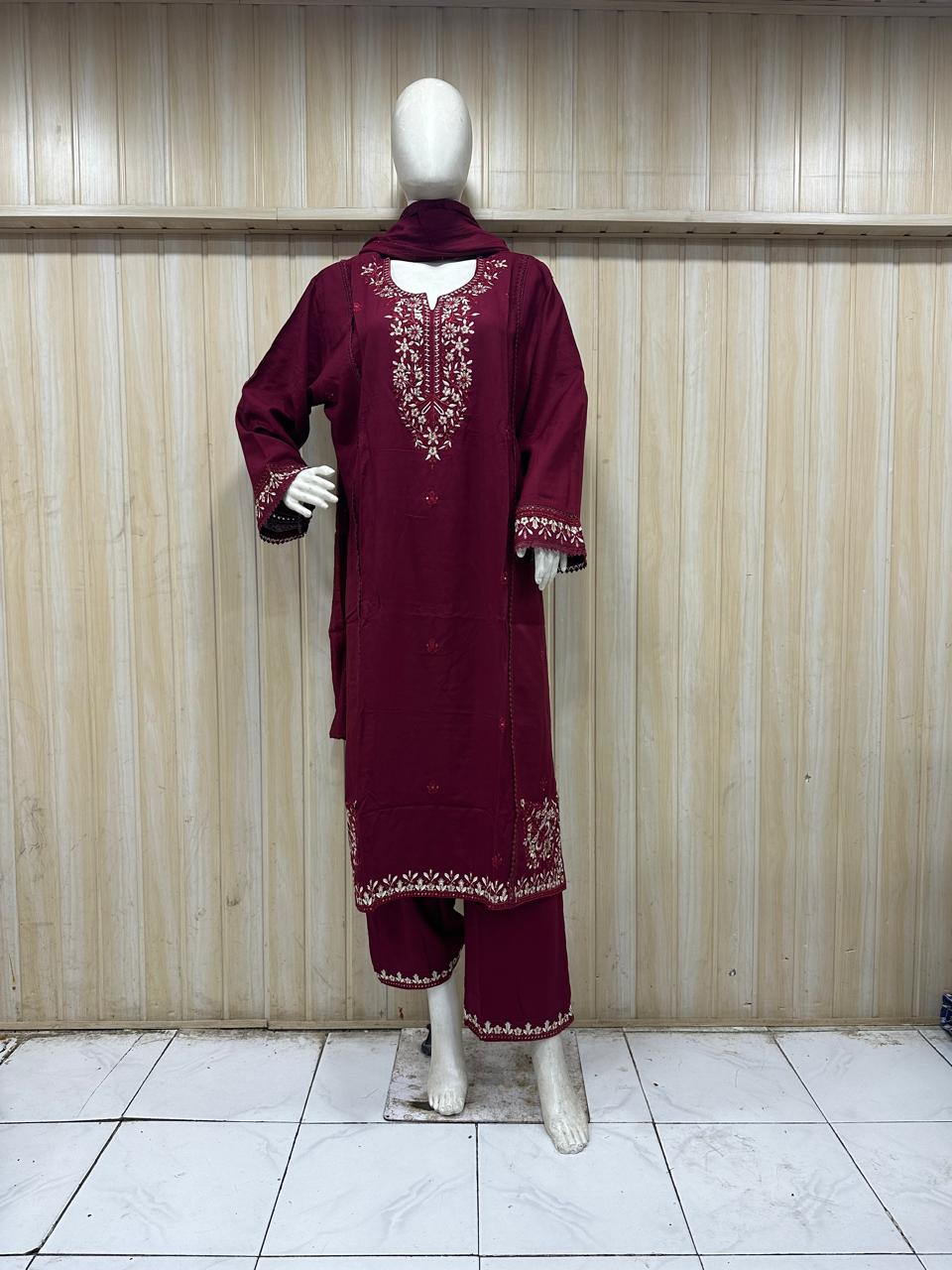dark red gold traditional outfit with matching dupatta on a mannequin against a striped