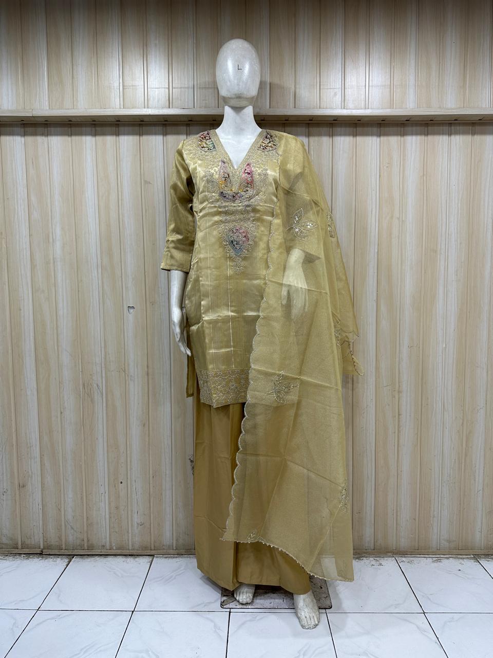dark yellow gold traditional outfit with matching dupatta on a mannequin against a striped