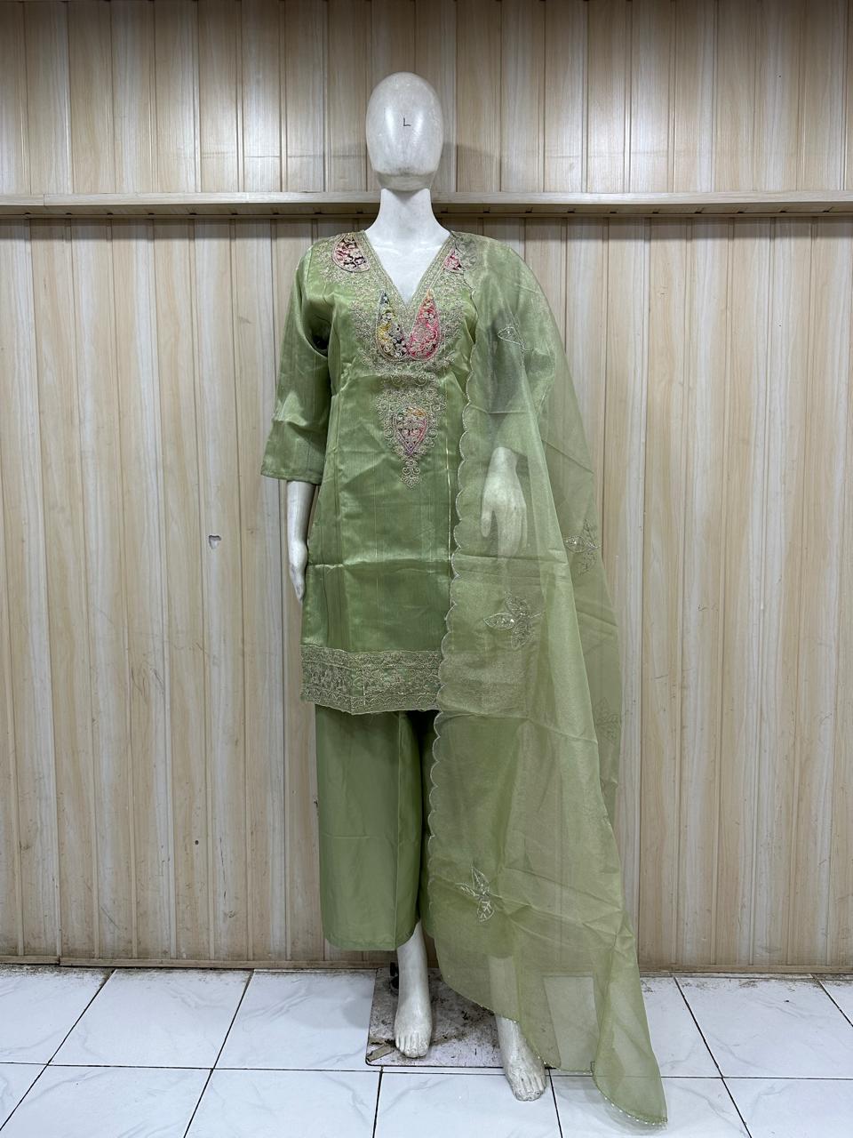 dar green gold traditional outfit with matching dupatta on a mannequin against a striped