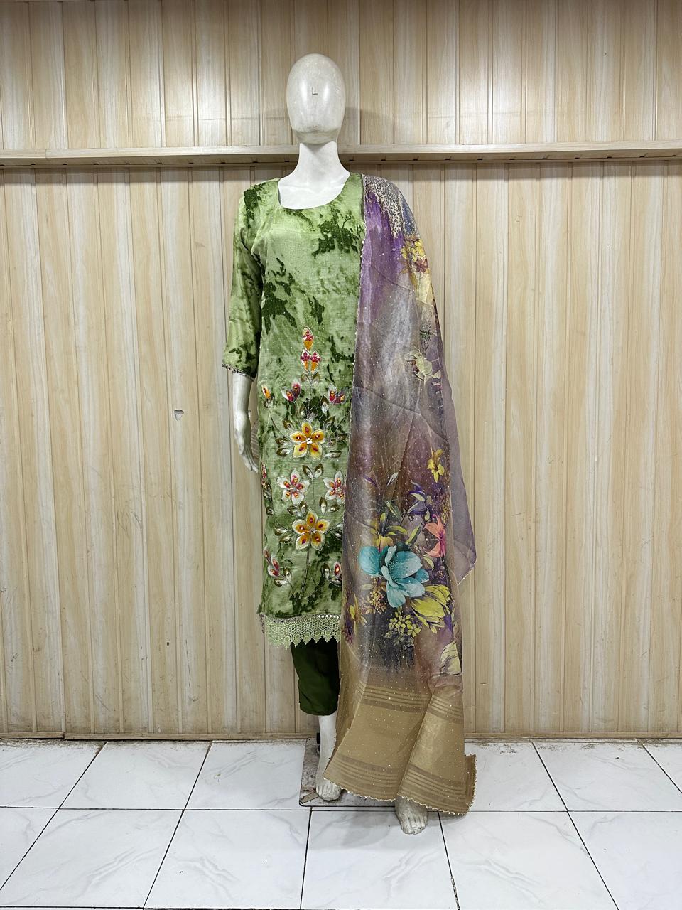 Mannequin wearing a green floral dress with a matching dupatta against a striped
