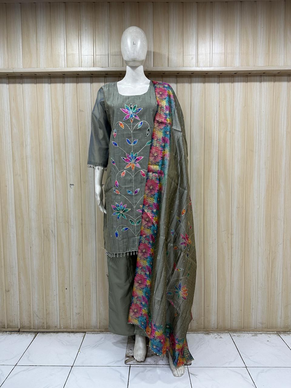 Mannequin wearing a grey floral dress with a matching dupatta against a striped