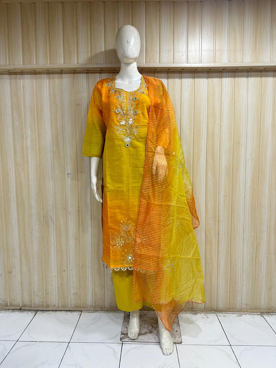 Yellow and orange traditional outfit on a mannequin against a striped