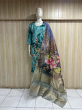 Mannequin wearing a floral dress with a matching scarf against a wooden panel background