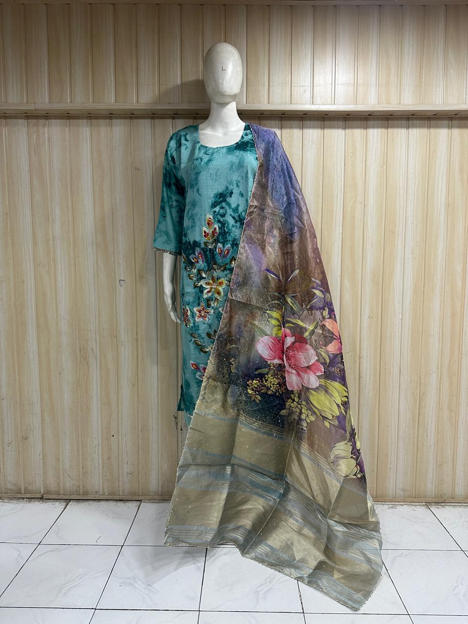 Mannequin wearing a floral dress with a matching scarf against a wooden panel background