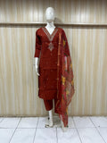 Red traditional outfit with floral patterns on a mannequin against a striped