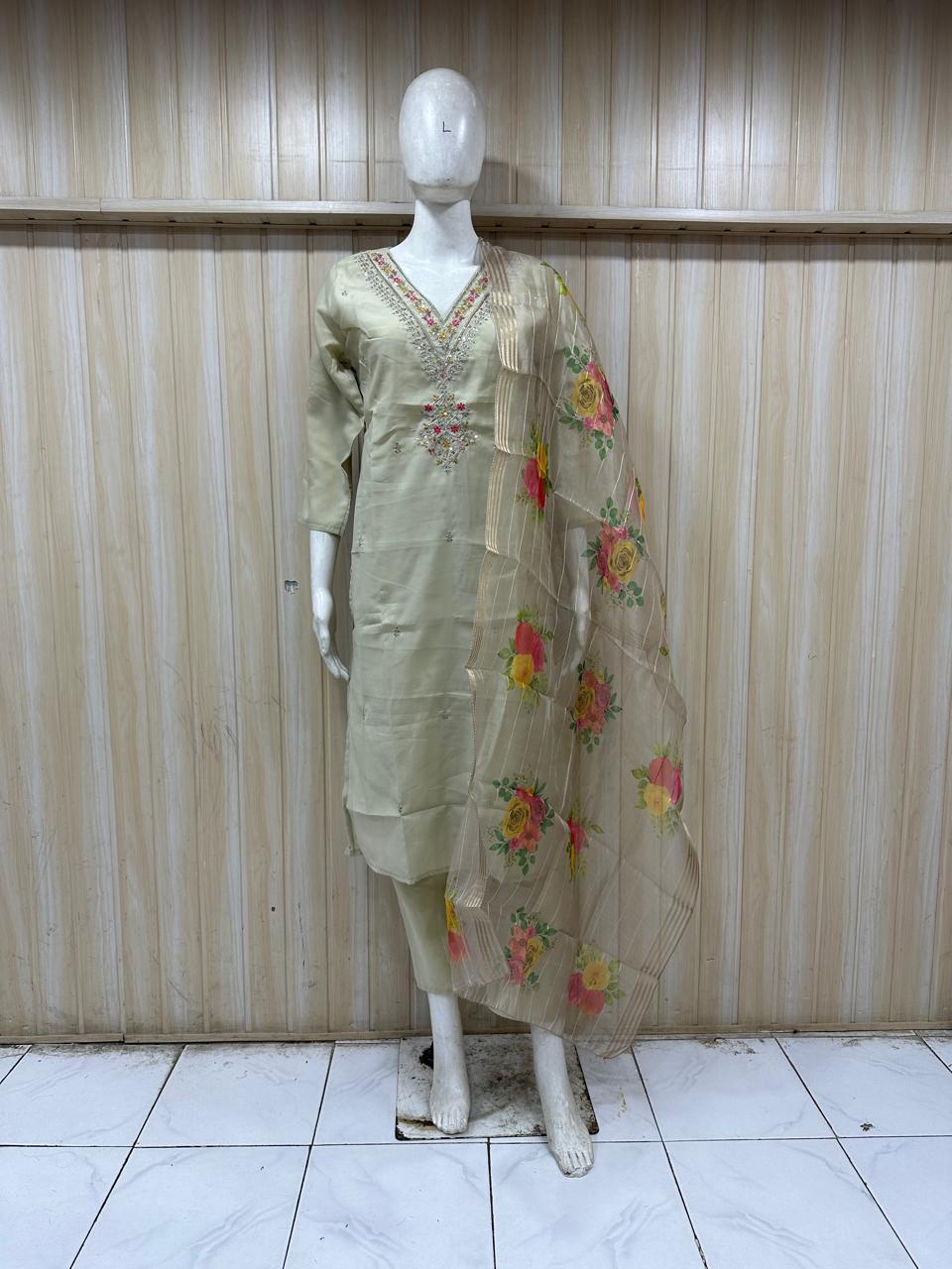 beige traditional outfit with floral patterns on a mannequin against a striped