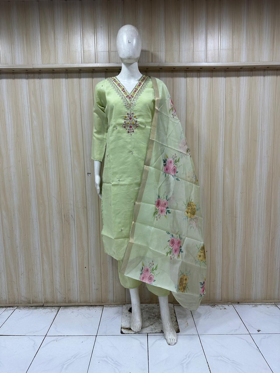 Light green traditional outfit with floral dupatta on a mannequin against a striped