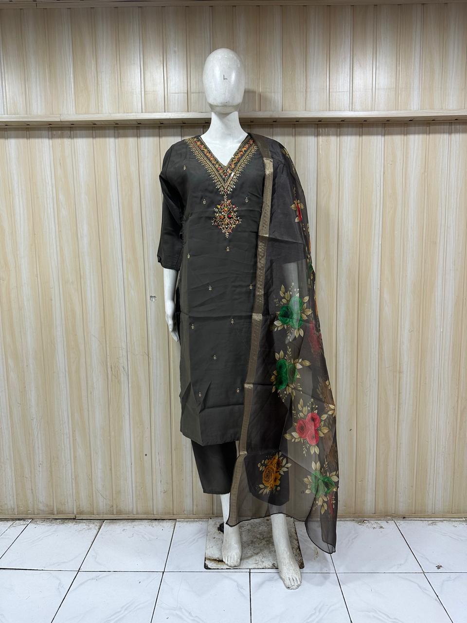 Mannequin wearing a dark grey traditional outfit with floral dupatta against a striped