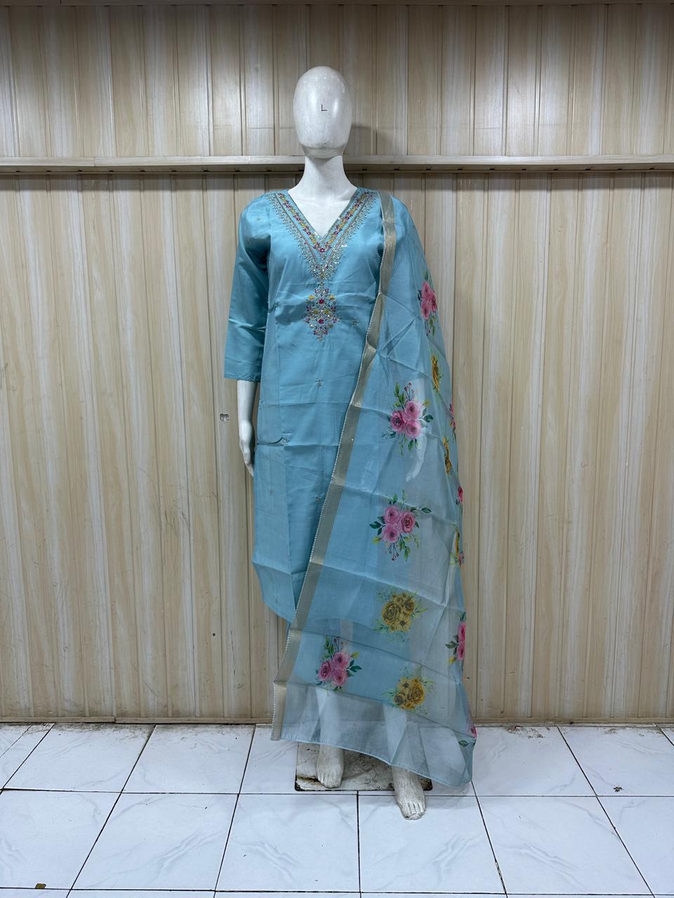 Mannequin wearing a blue traditional outfit with floral patterns against a striped