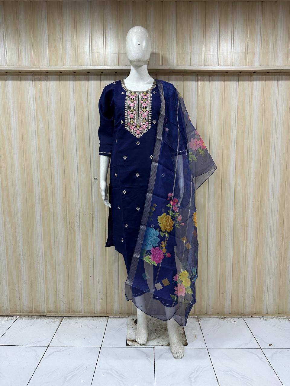 Navy blue embroidered outfit with a floral dupatta on a mannequin against a striped