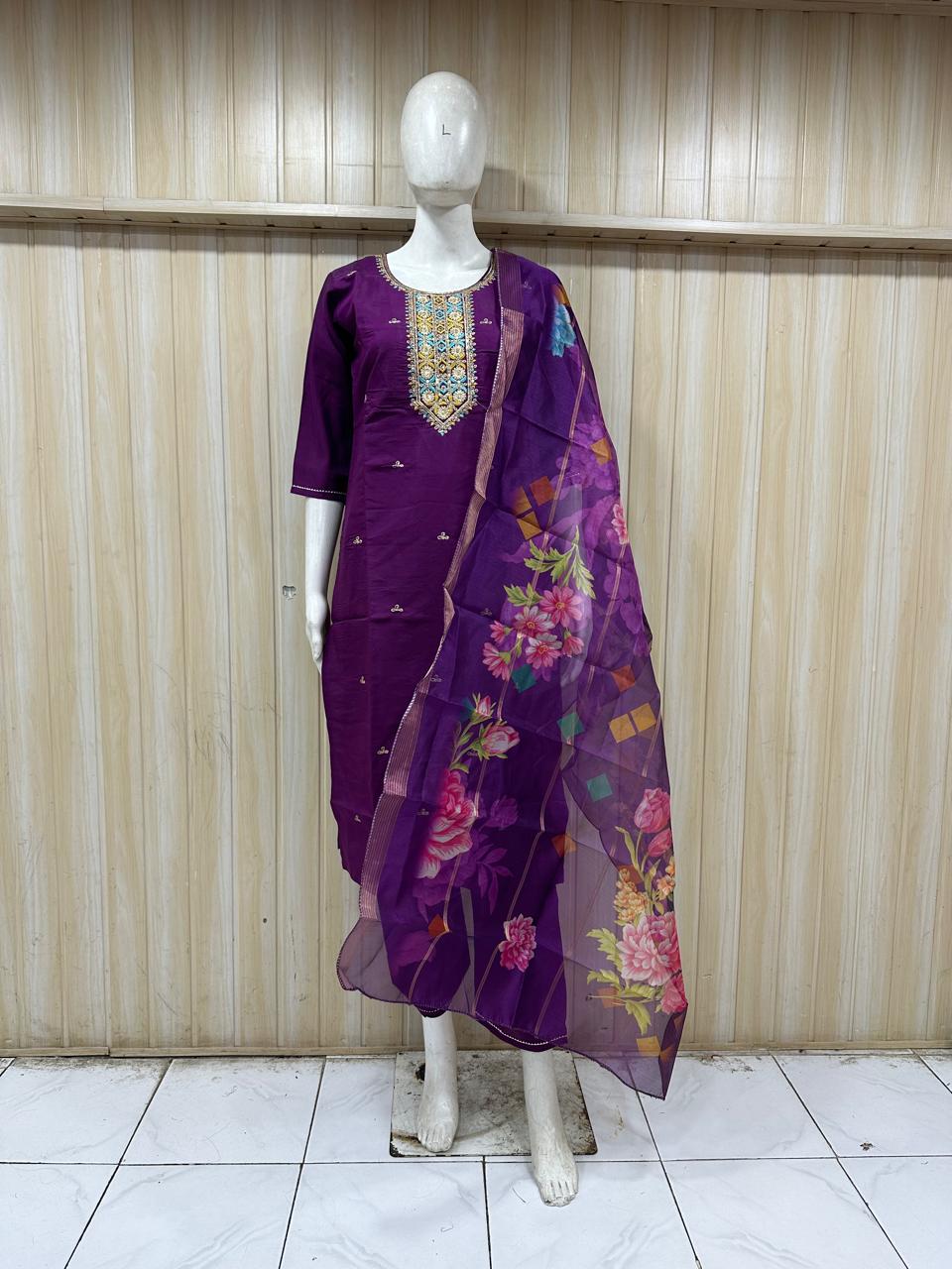 purple embroidered outfit with a floral dupatta on a mannequin against a striped