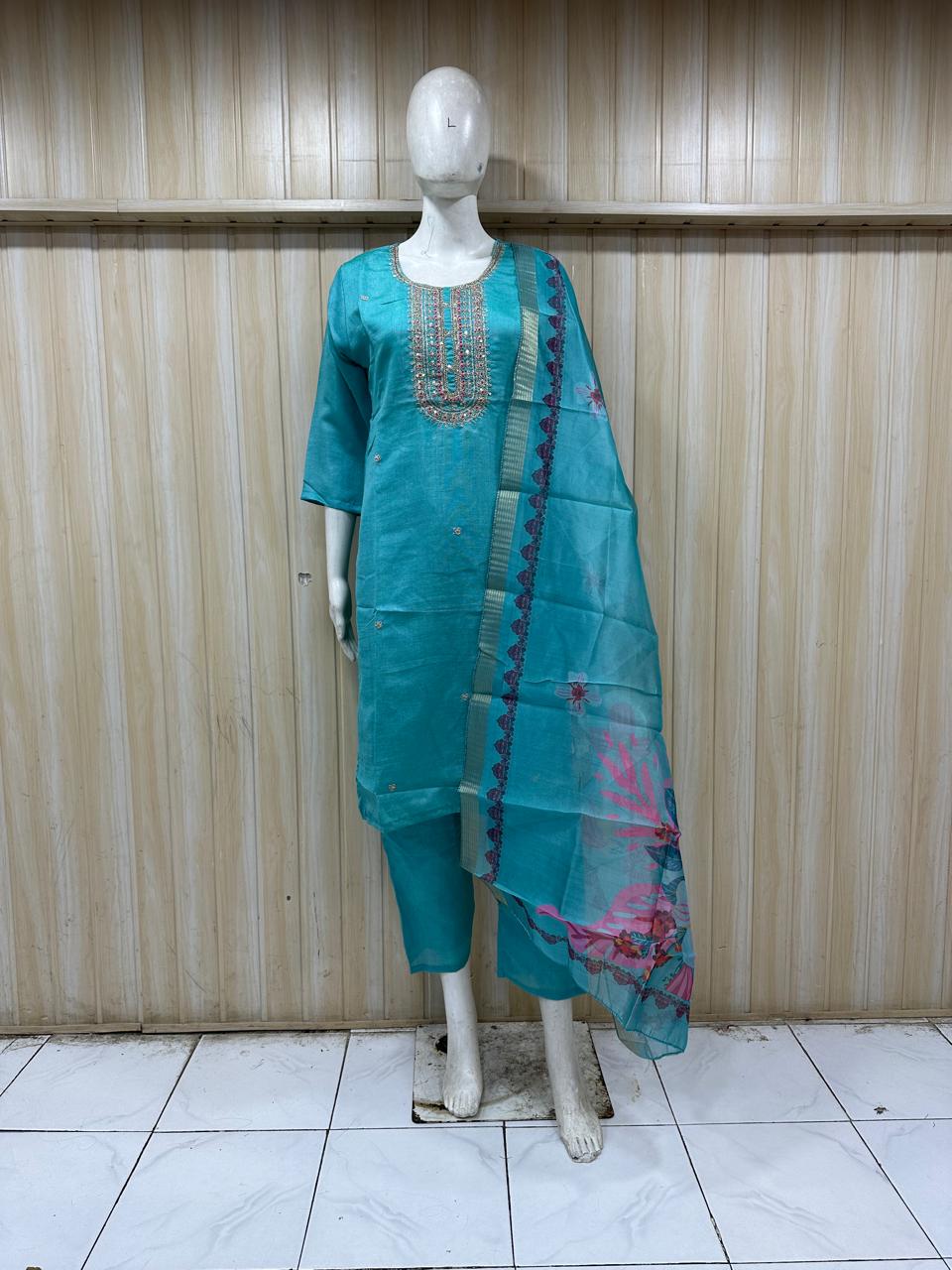 sky blue gold embroidered outfit with a floral dupatta on a mannequin against a striped