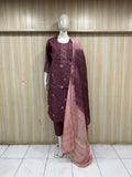 Mannequin wearing a maroon traditional outfit with a pink dupatta against a striped