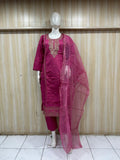 Pink traditional outfit with embroidered details on a mannequin against a striped