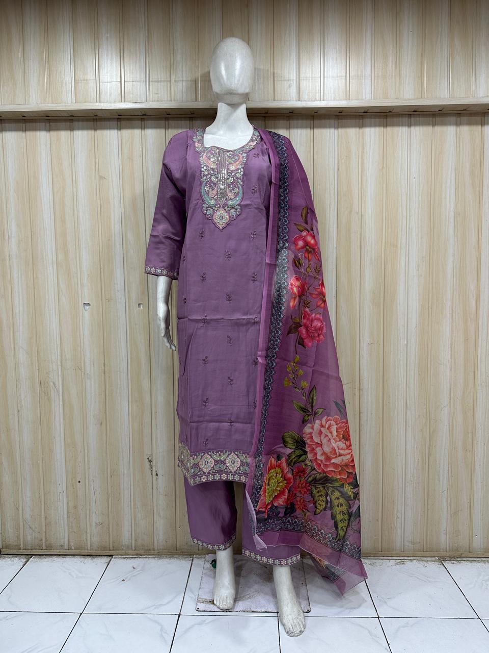 Mannequin wearing a purple traditional outfit with a saree against a wooden panel background