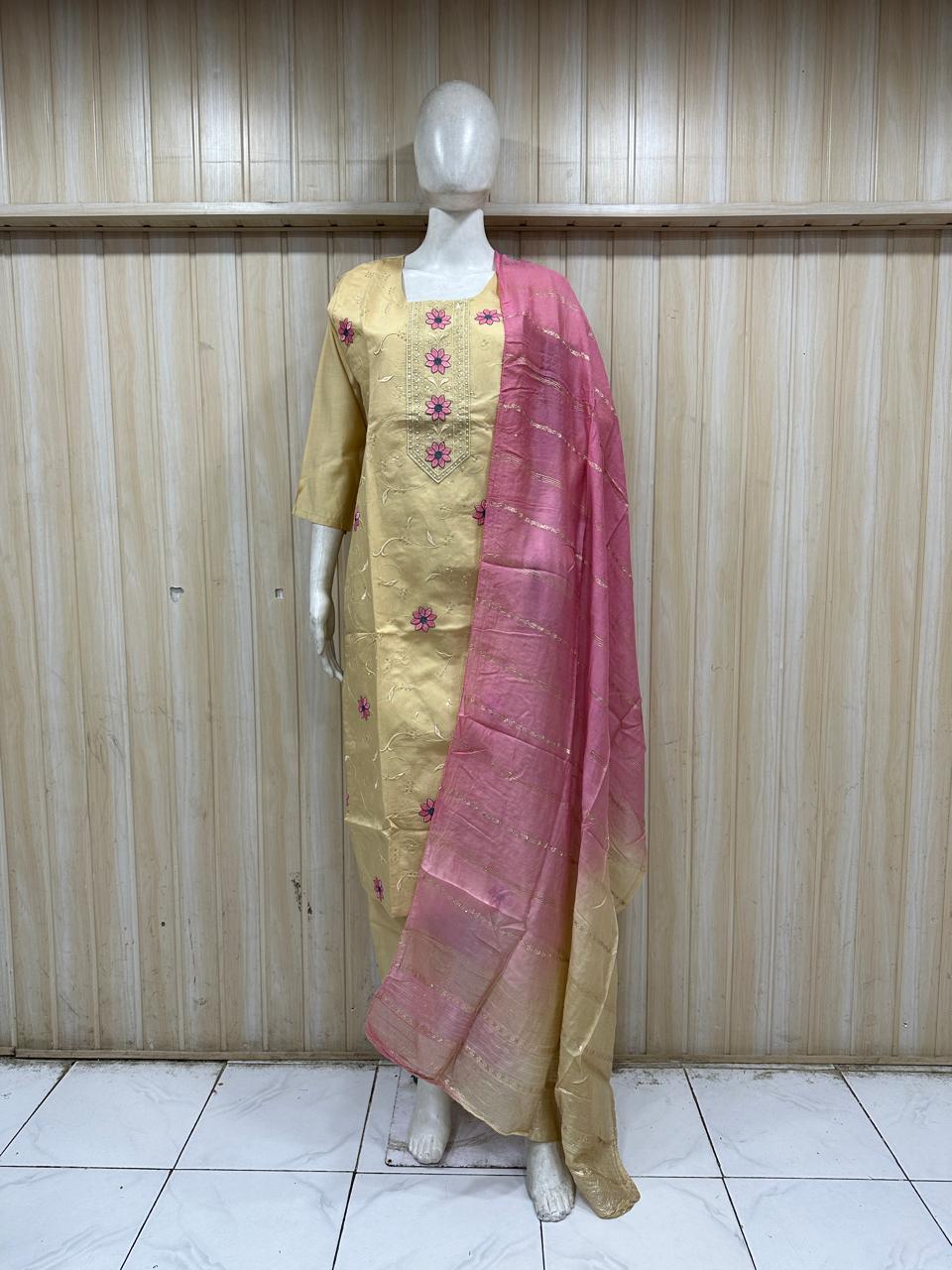 Mannequin wearing a yellow dress with pink dupatta against a striped