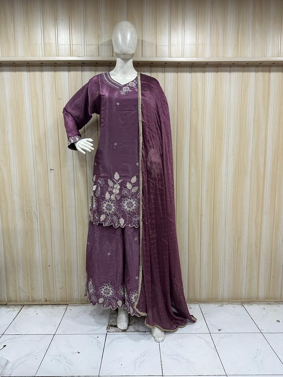 purple embroidered traditional outfit on a mannequin against a striped