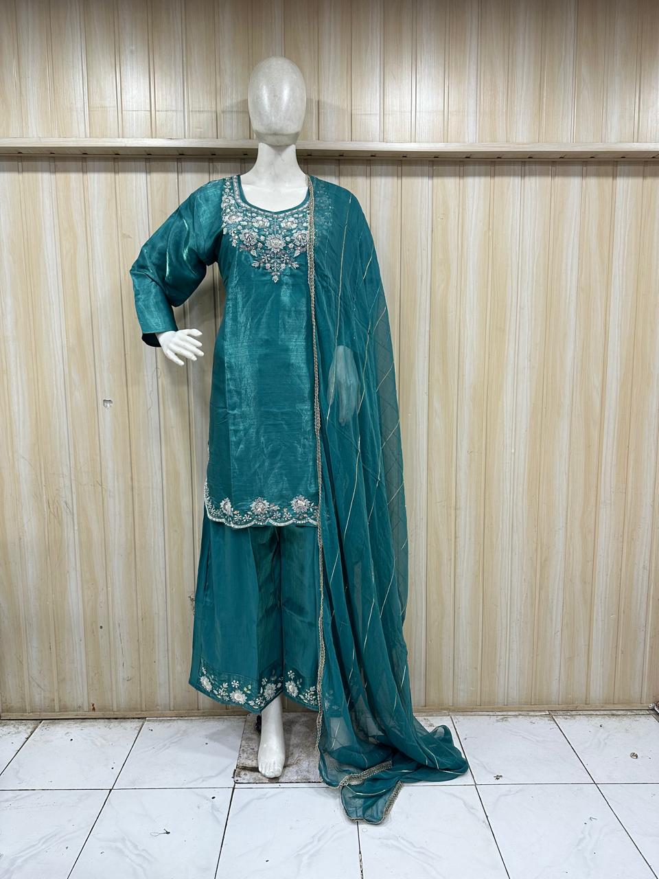 blue andwhite embroidered traditional outfit on a mannequin against a striped