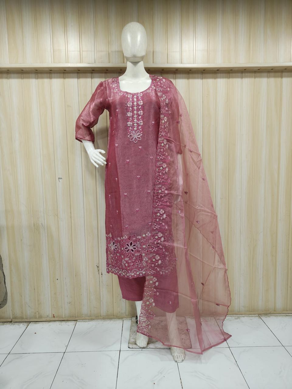 rose gold traditional outfit with gold embroidery on a mannequin against a striped