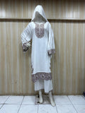 white embroidered traditional outfit on a mannequin against a striped