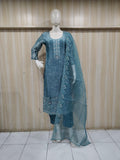 Mannequin wearing a blue embroidered traditional outfit against a striped