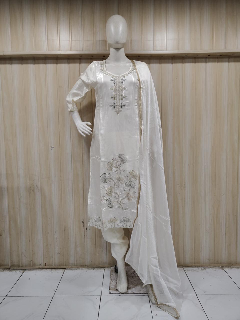 Mannequin wearing a white embroidered traditional outfit against a striped
