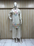 Mannequin wearinMannequin wearing a white embroidered outfit against a striped