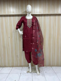 maroon embroidered outfit on a mannequin against a striped