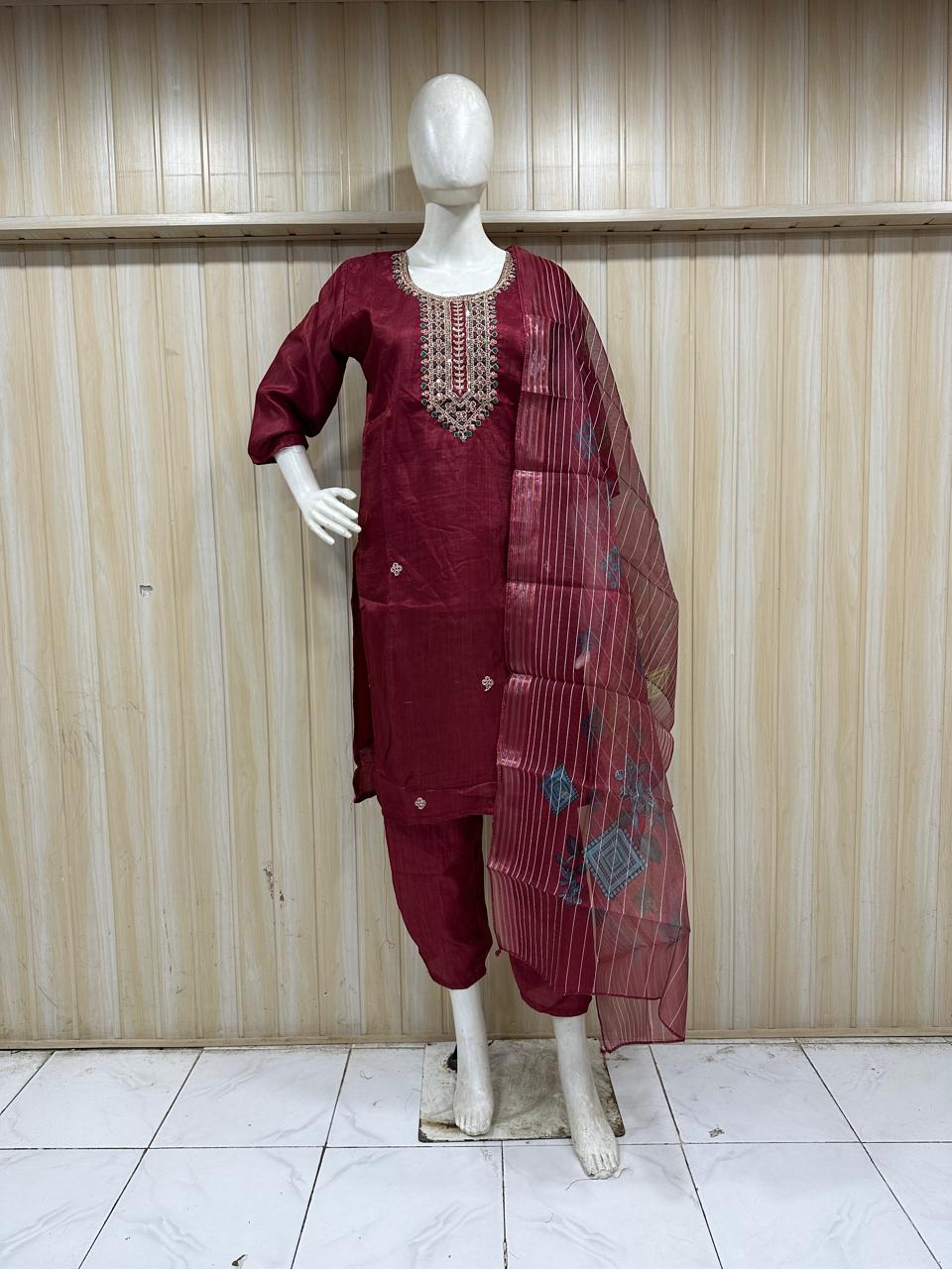maroon embroidered outfit on a mannequin against a striped