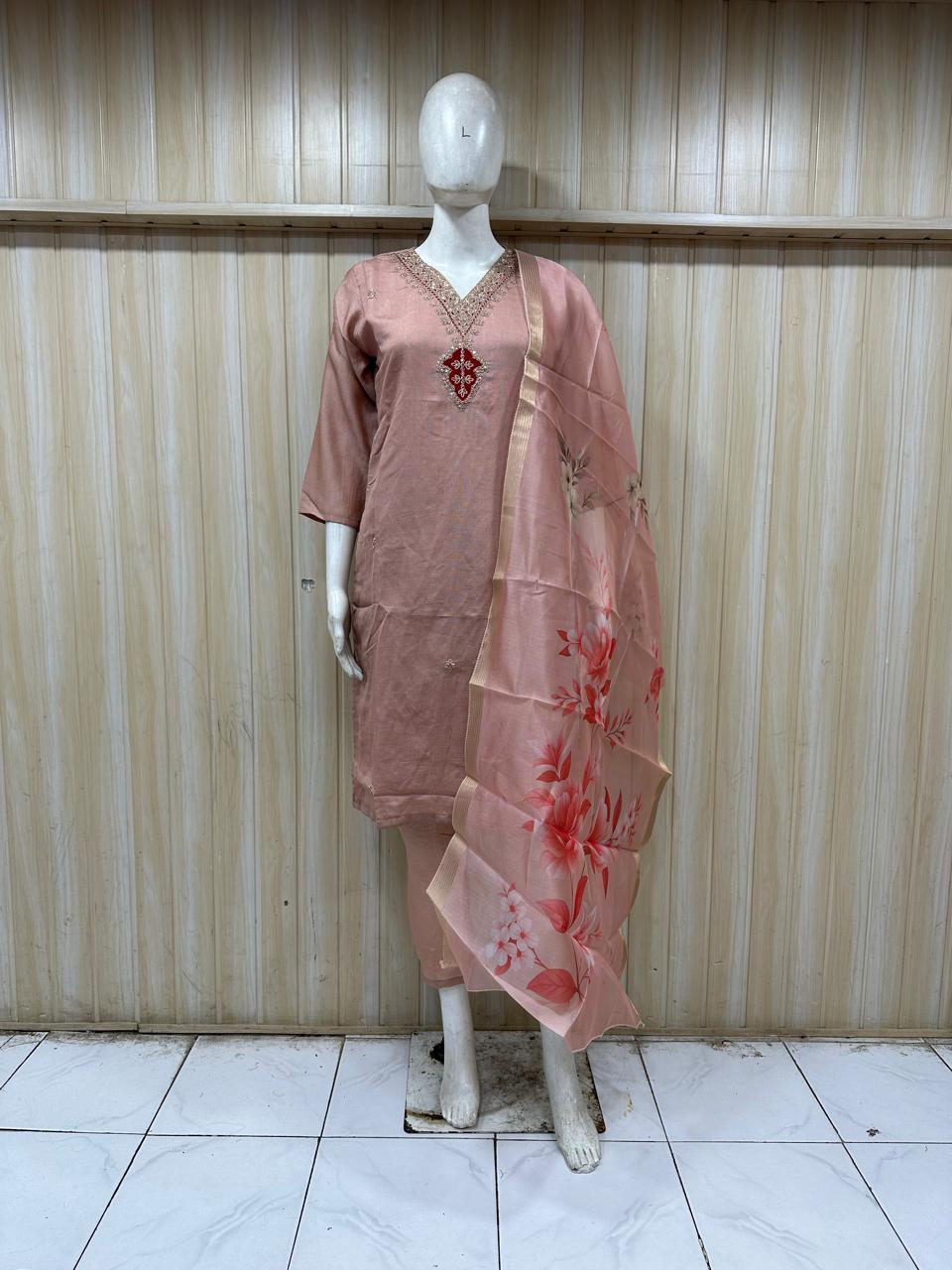 pink gold traditional outfit with a dupatta on a mannequin against a striped