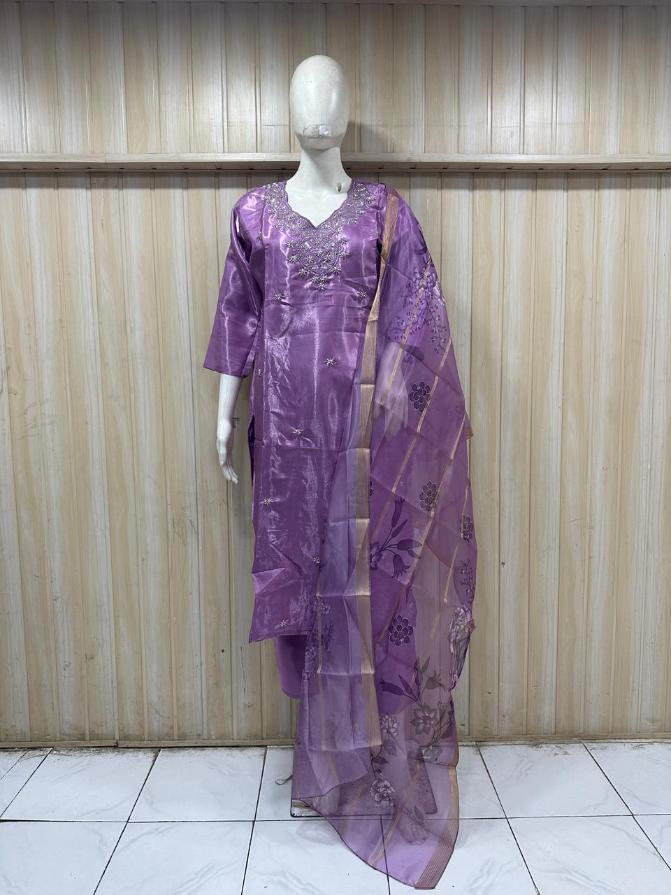 purple gold traditional outfit with a dupatta on a mannequin against a striped