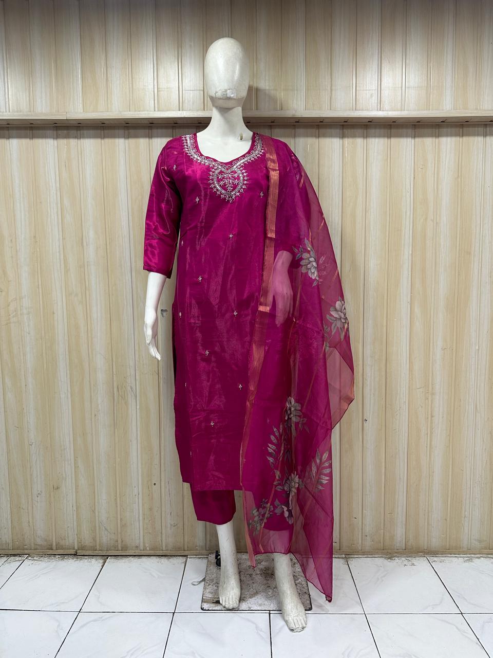 dark pink gold traditional outfit with a dupatta on a mannequin against a striped
