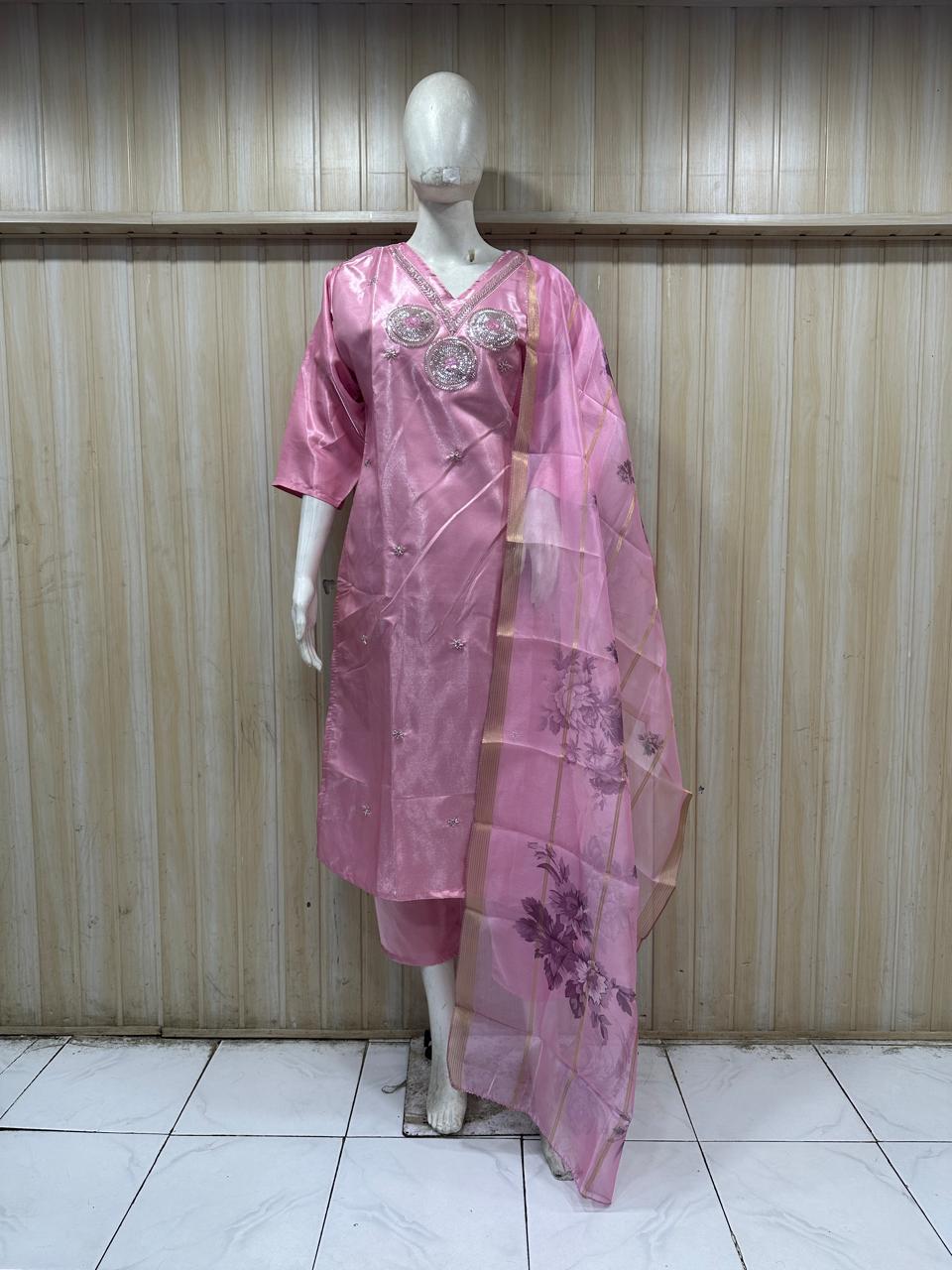 Mannequin wearing a pink traditional outfit with a floral dupatta against a striped