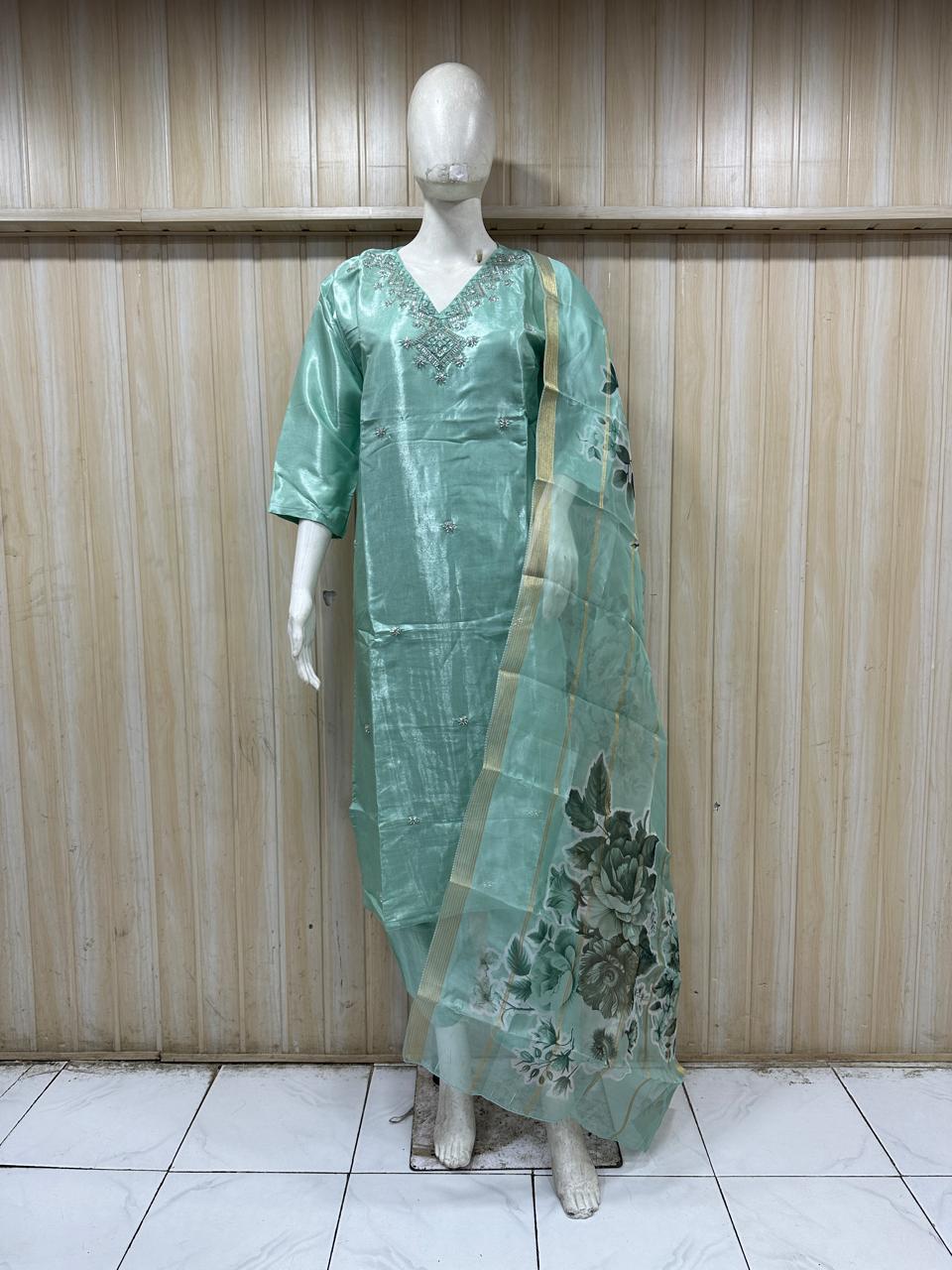 Mannequin wearing a gometry traditional outfit with a floral dupatta against a striped