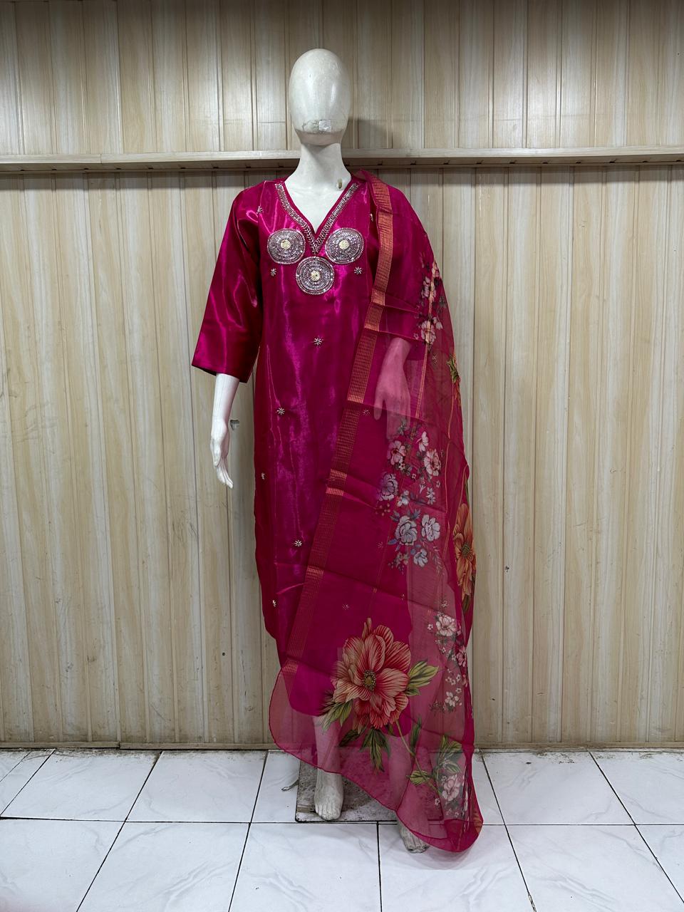 Mannequin wearing a red floral dress against a striped