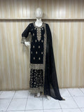 Mannequin wearing a black floral dress against a striped