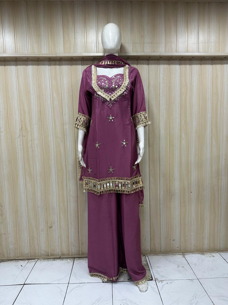 Mannequin wearing a rose gold traditional outfit with a floral dupatta against a striped