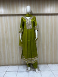 green embroidered dress with a matching dupatta on a mannequin against a striped