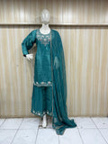 blue embroidered dress with a matching dupatta on a mannequin against a striped
